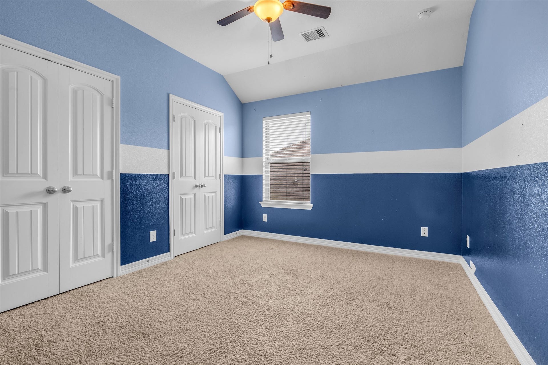7 Ember Branch Drive, Missouri City, TX 77459 An upstairs secondary bedroom with a vaulted ceiling, ceiling fan and double-door closet, ready for guests or a home office.