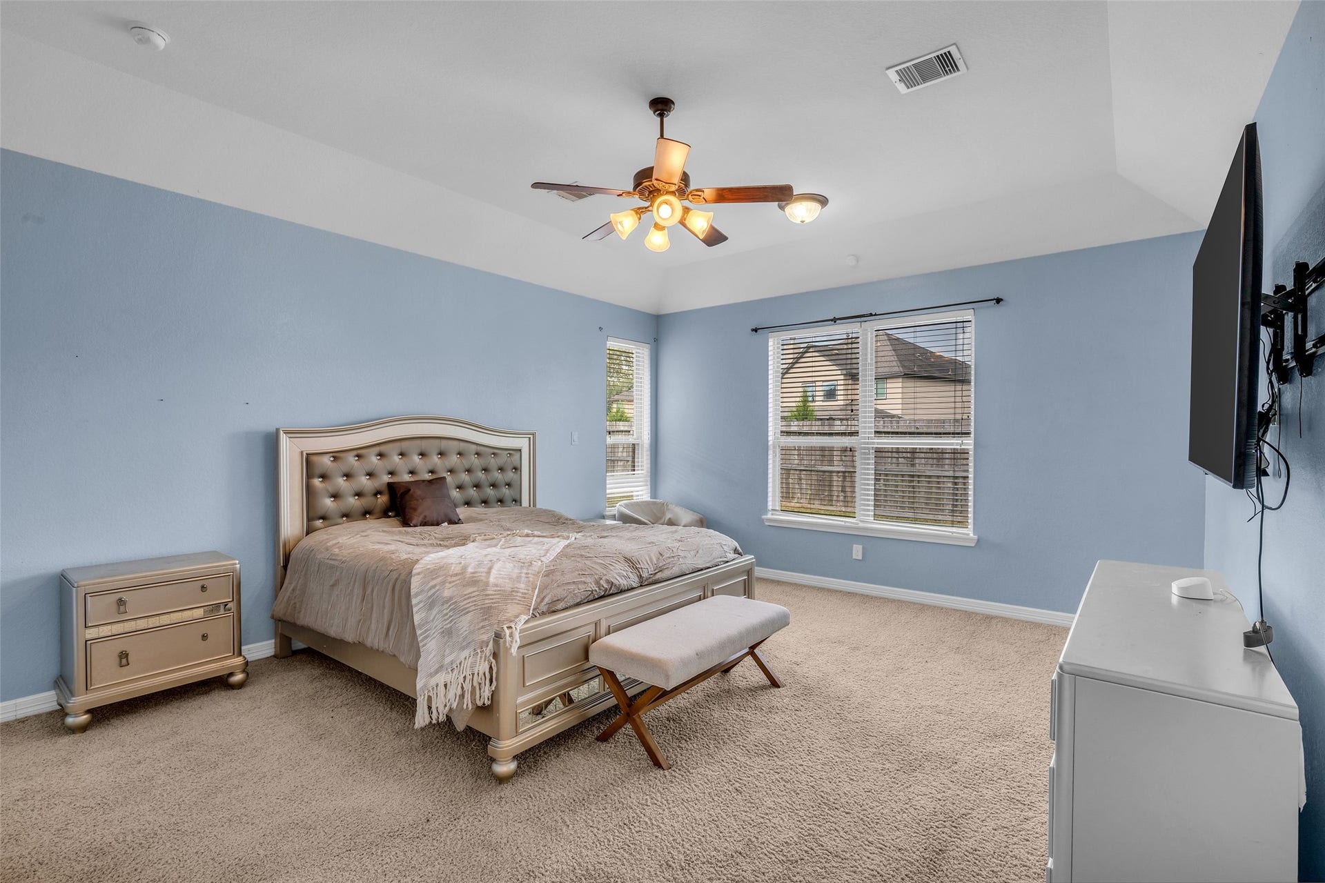 7 Ember Branch Drive, Missouri City, TX 77459 Retreat to the spacious first-floor primary bedroom, with plush carpet, a ceiling fan and windows overlooking the backyard.