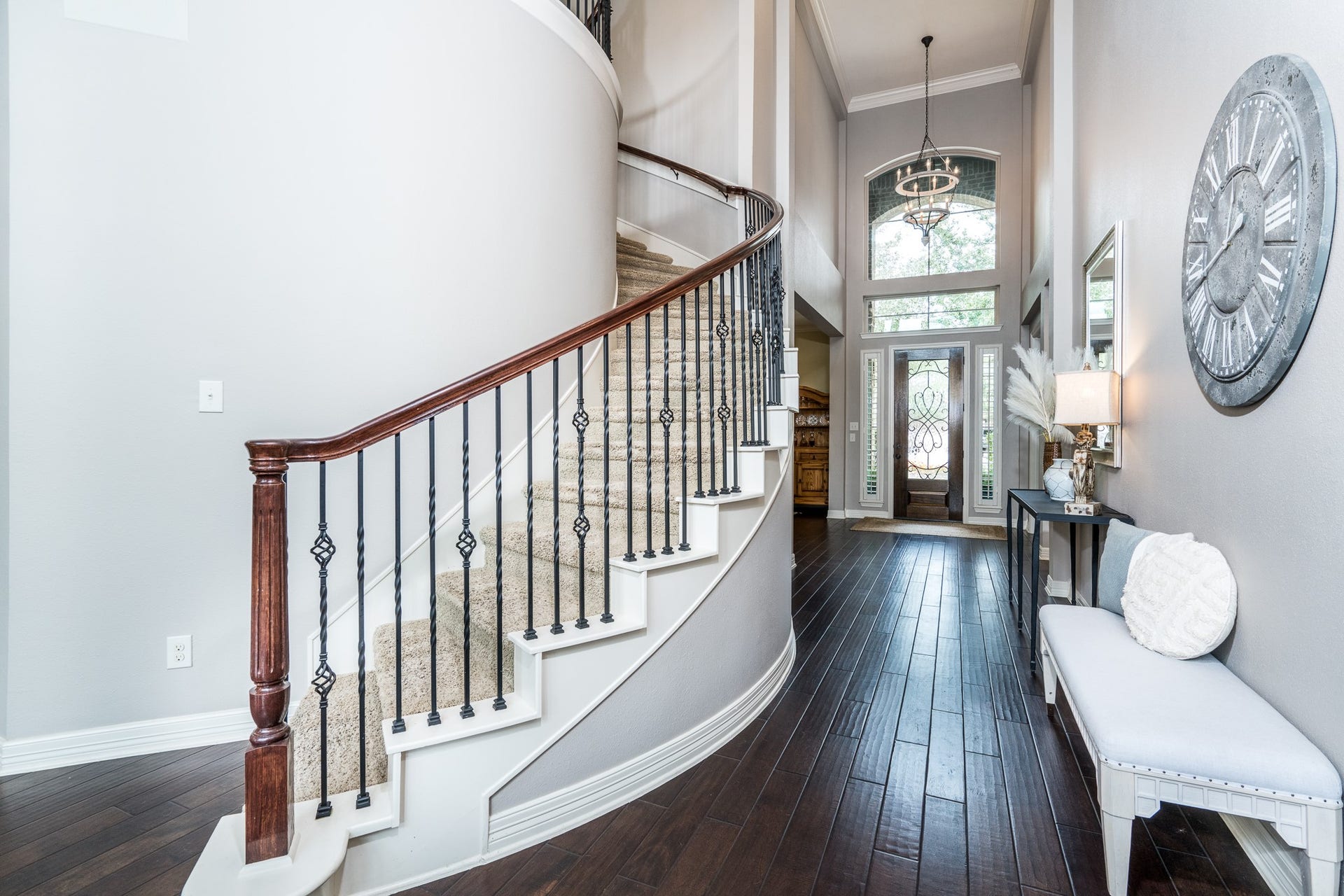 A majestic, curved staircase with wrought iron balusters, a mahogany stained front door with transom windows and a spectacular chandelier create the perfect accents to this warm and welcoming space!