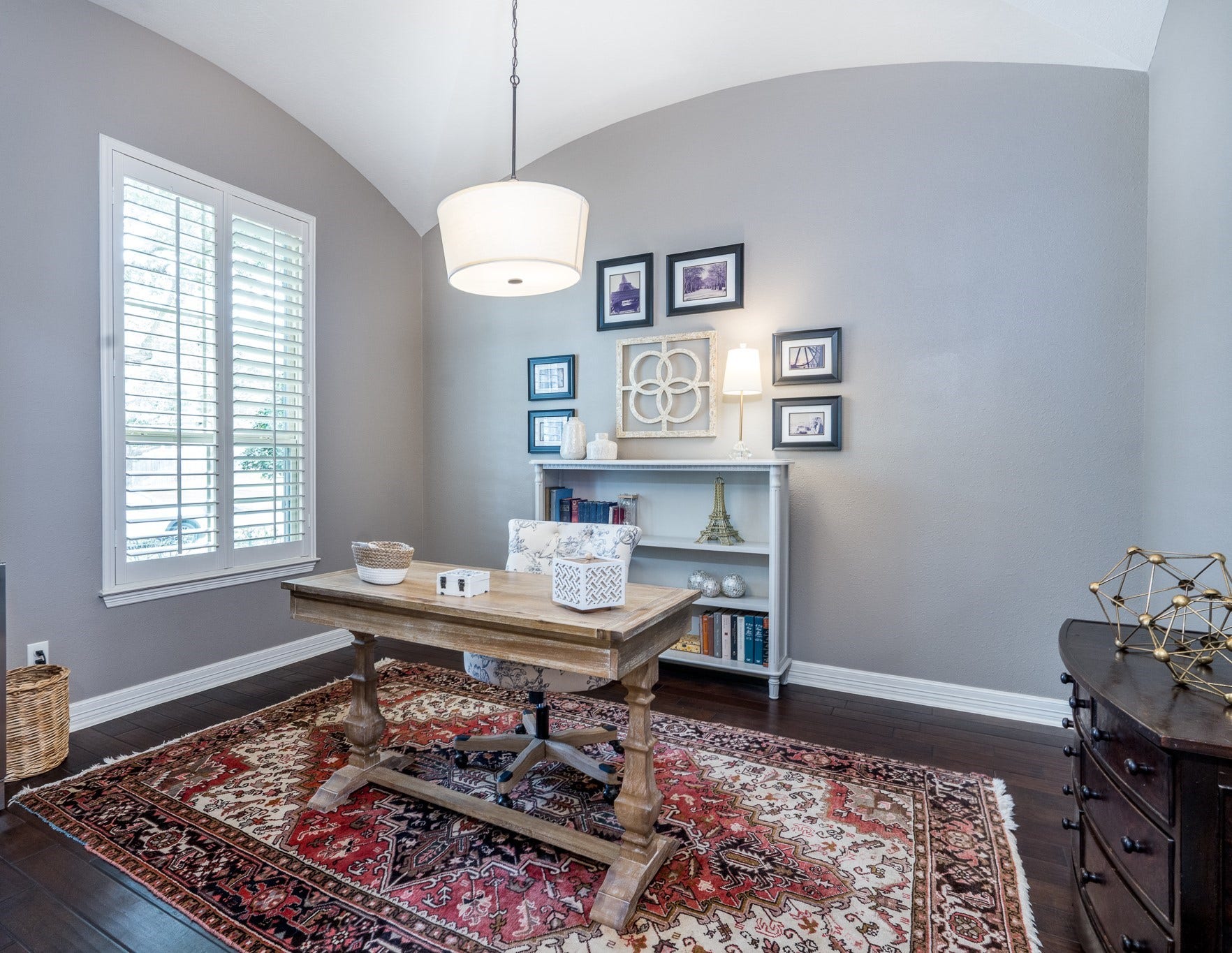 To the left of the entry is this private study with double French doors, hardwood floors, crown molding, plantation shutters and arched ceiling, all the special touches to bring style to your workspace!