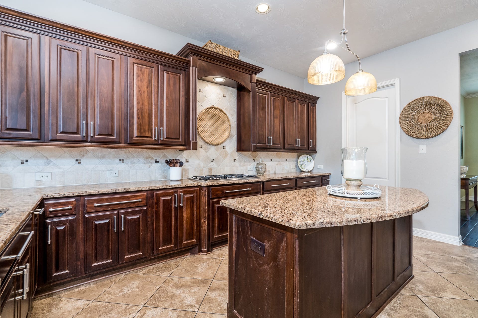 Mahogany stained cabinets, granite countertops, tumbled travertine backsplash and stainless steel appliances including a 5 burner cooktop...all waiting for the resident chef!