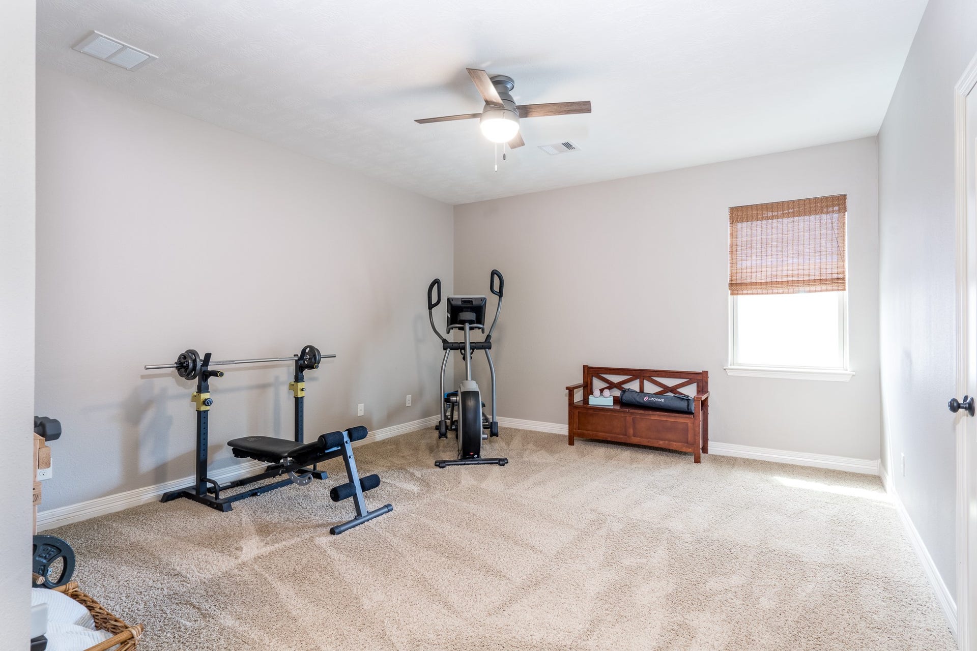 The fourth of four secondary bedrooms is currently being utilized as a home gym. It offers neutral carpet, walk-in closet and ceiling fan! All secondary bedrooms boast a large footprint, making arranging your favorite furniture a breeze!