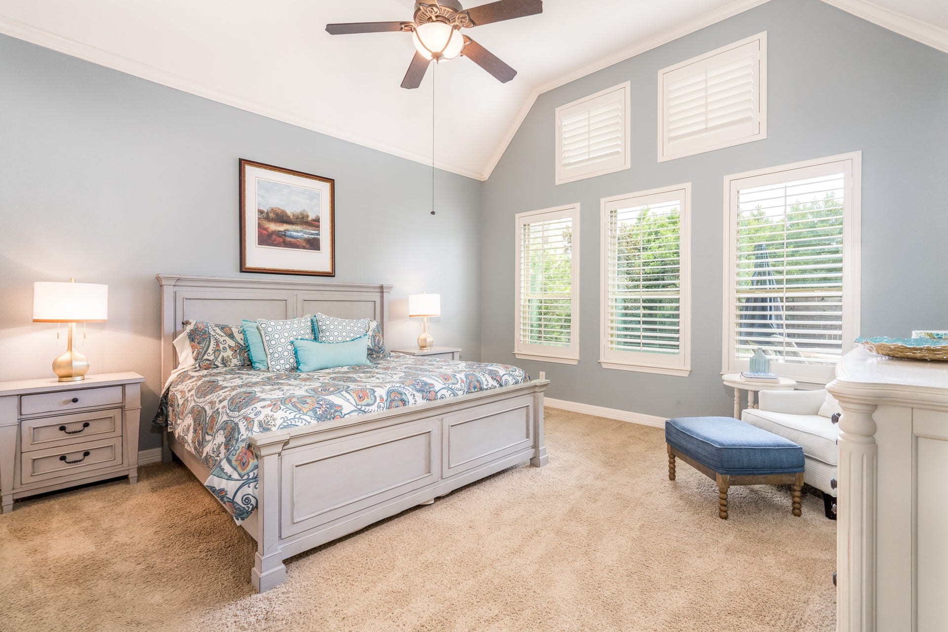 Welcome to your luxurious primary suite! A wall of windows with plantation shutters sheds light into this serene space that also boasts a vaulted ceiling!