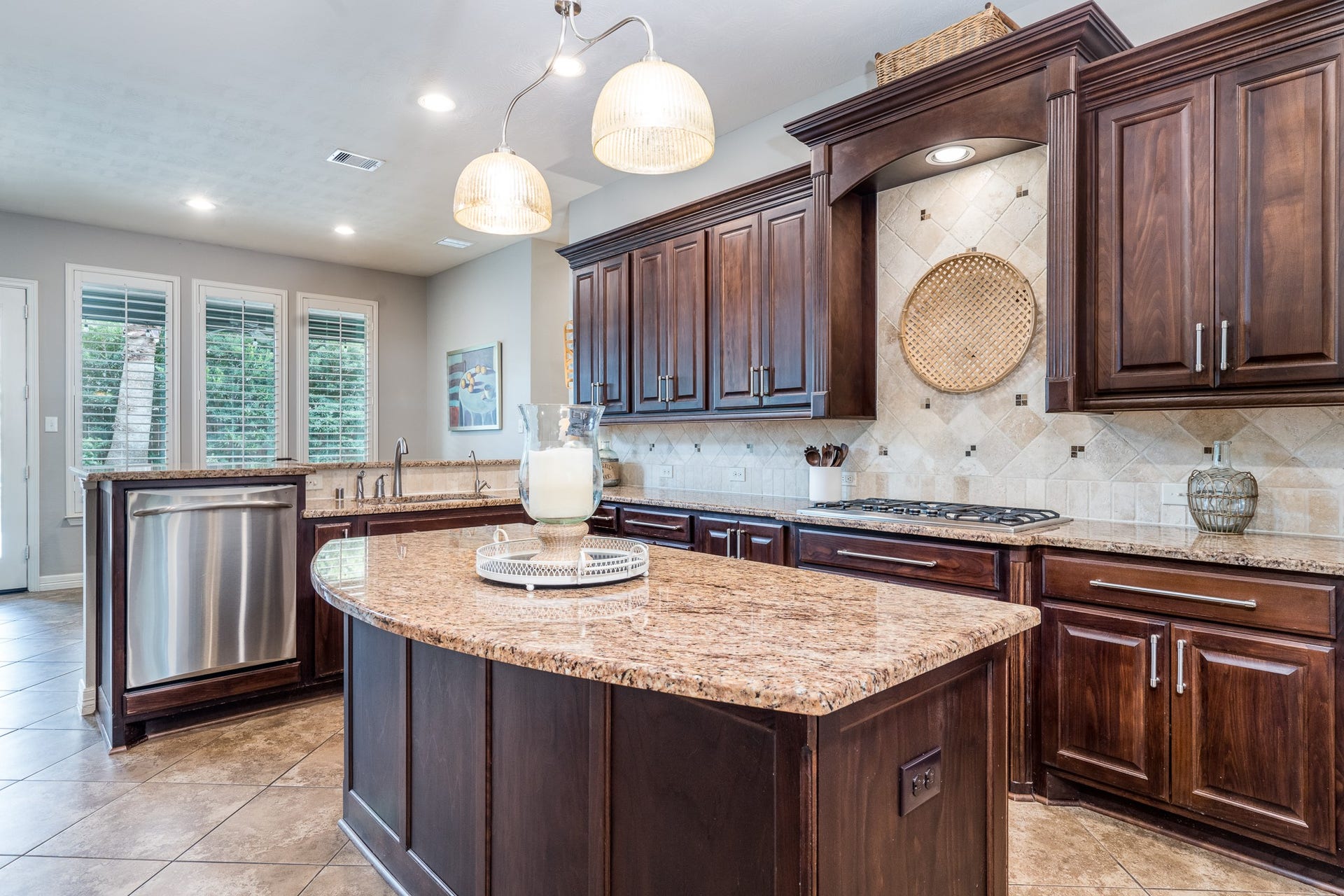 Charming brushed nickel pendant with mercury glass globes adorn the kitchen's center island, adding style to this prep space!