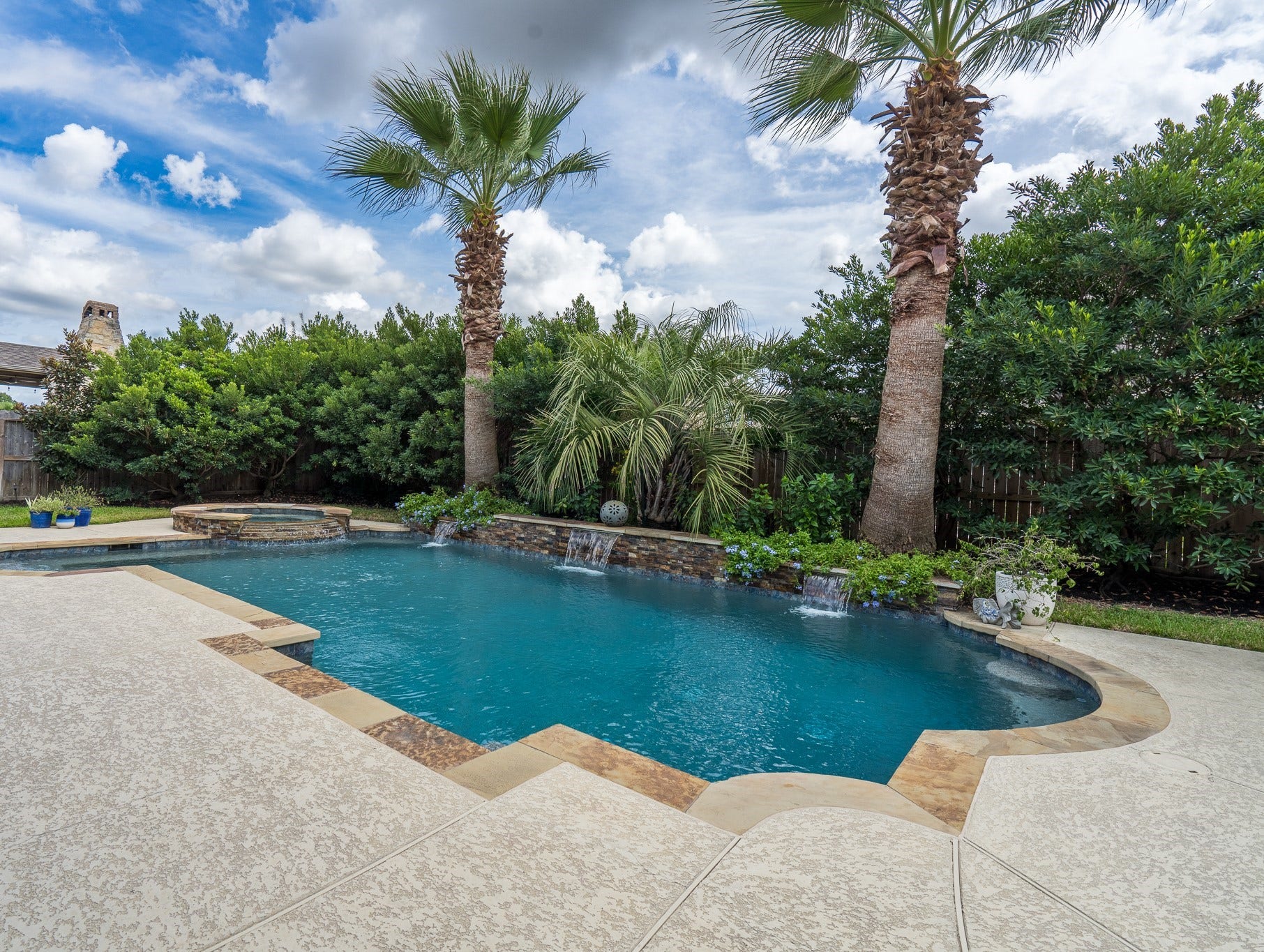 The pool features a flagstone raised wall with scuffers, pebble sheen and multiple bench seating! The eastern facing yard offers warm morning sun and cool afternoon shade for those hot summer days!