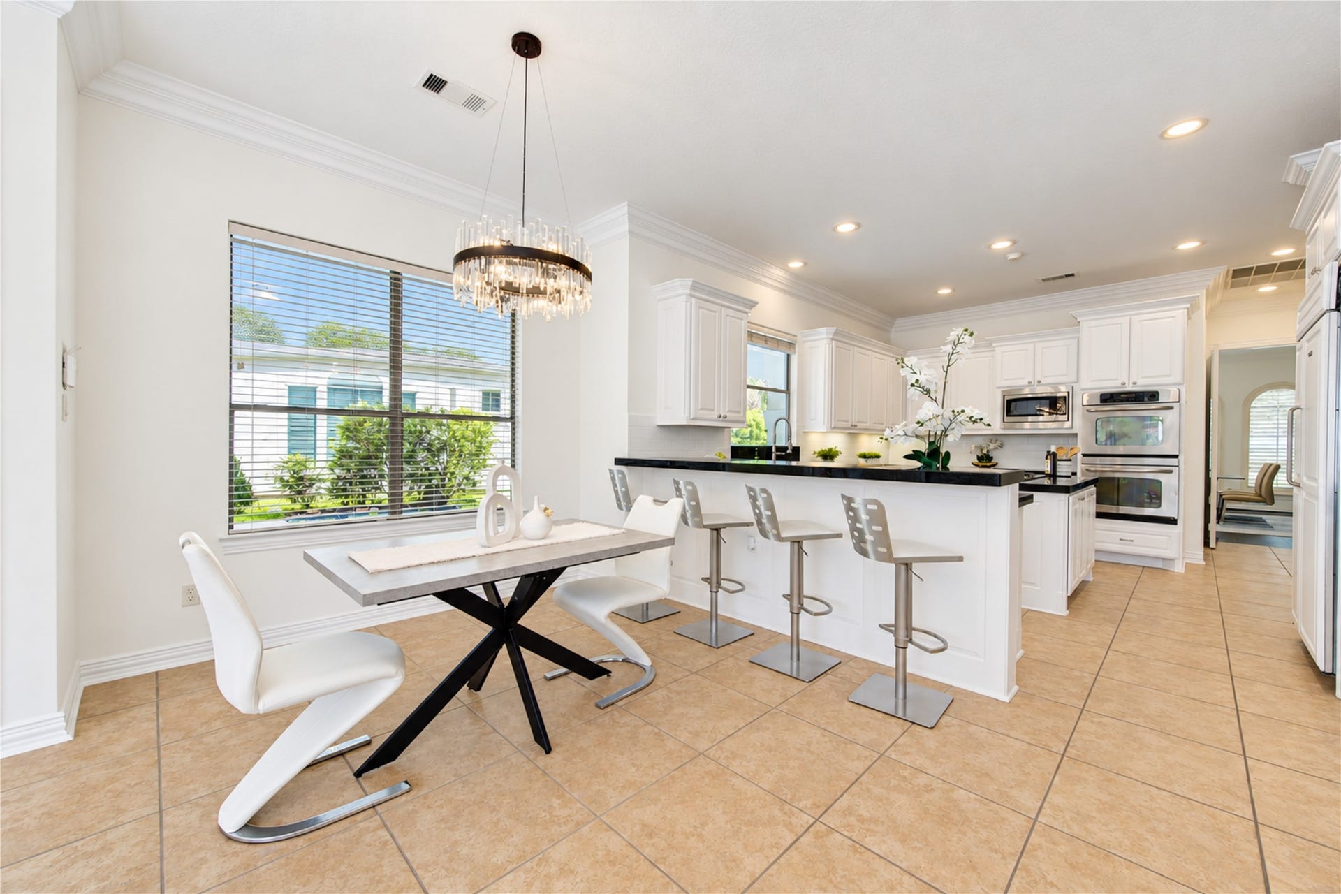 14014 Hampton Cove Drive, Houston, TX 77077 This beautifully designed open-concept kitchen seamlessly flows into the breakfast nook and gathering area, offering stunning, picturesque views of the private pool.