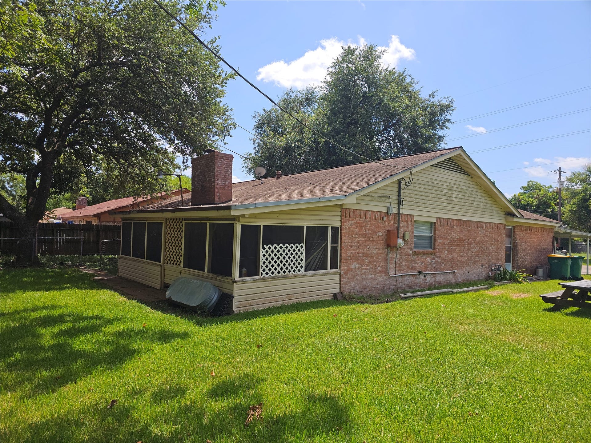 909 Lilac Street, La Marque, TX 77568 The screened back porch overlooks a spacious backyard, offering a comfortable place to relax, entertain, or enjoy the outdoors.