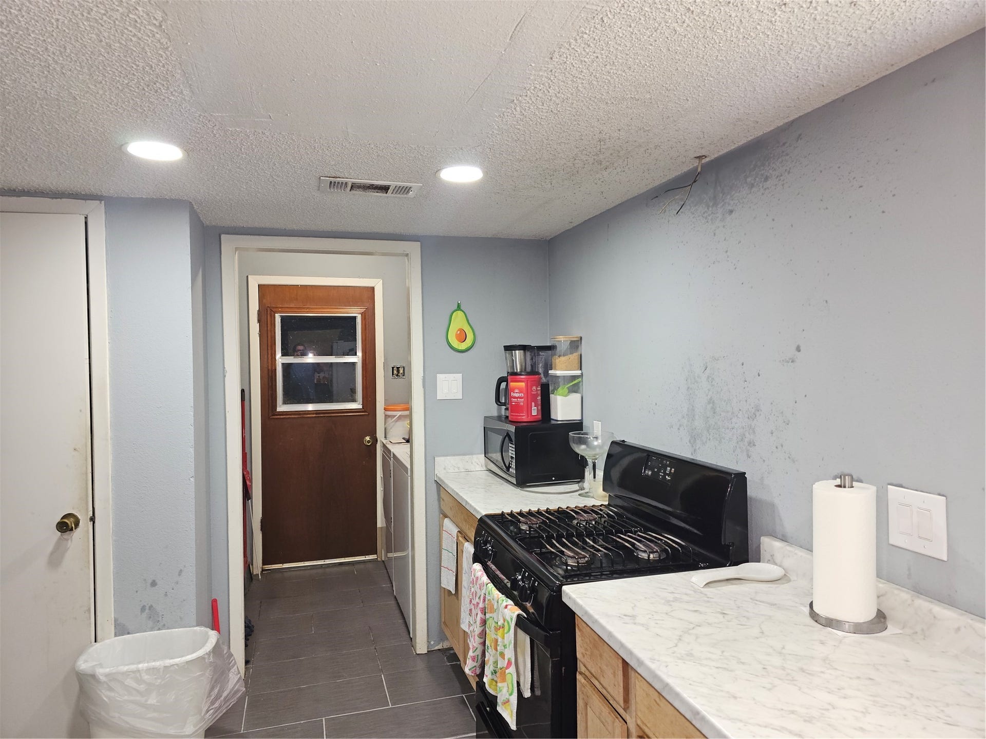 909 Lilac Street, La Marque, TX 77568 Kitchen features updated countertops, gas cooking, and a functional layout with easy access to the utility area.