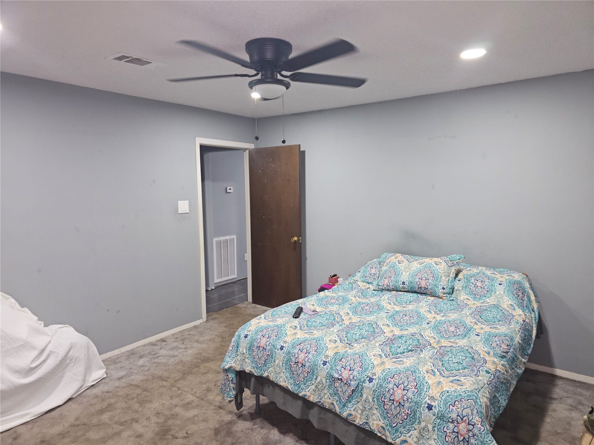 909 Lilac Street, La Marque, TX 77568 Spacious bedroom with soft carpeting, recessed lighting, ceiling fan, and neutral paint.
