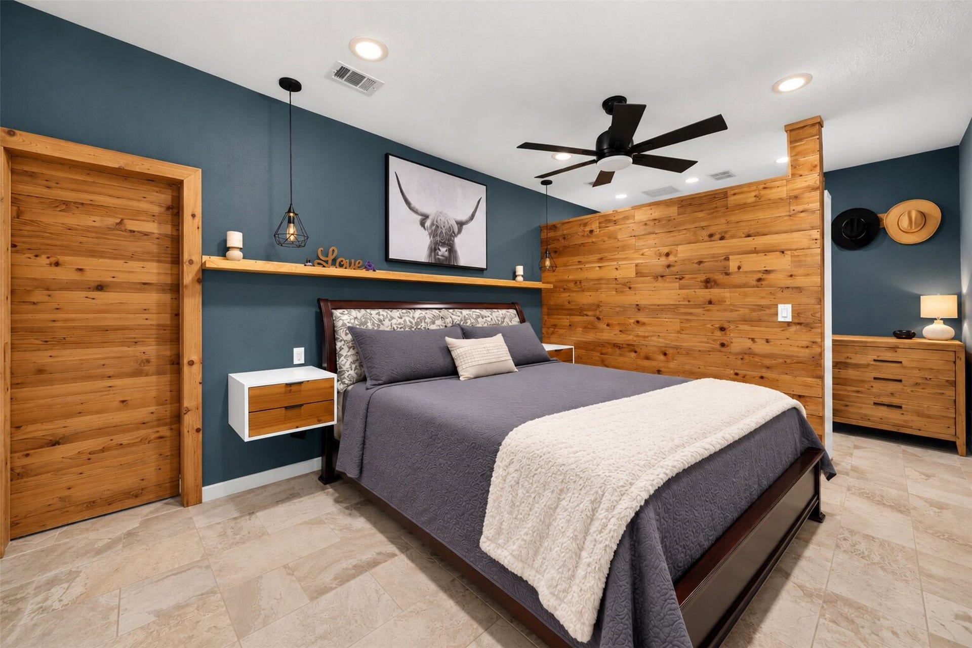 Bedroom features a deep blue accent wall, wood partition, bedside pendant lighting, and tile flooring.