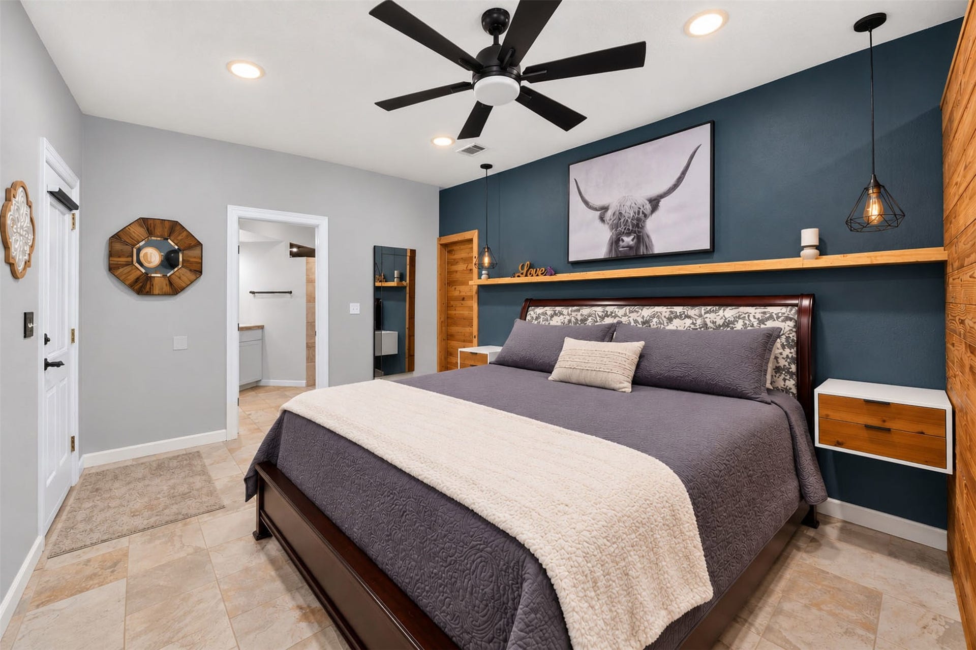Alternate bedroom view highlights wood accents, pendant lighting, and direct access to the adjoining bathroom.
