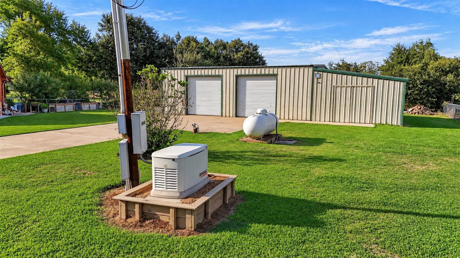 Exterior view shows a standby generator and propane tank near the detached metal building.