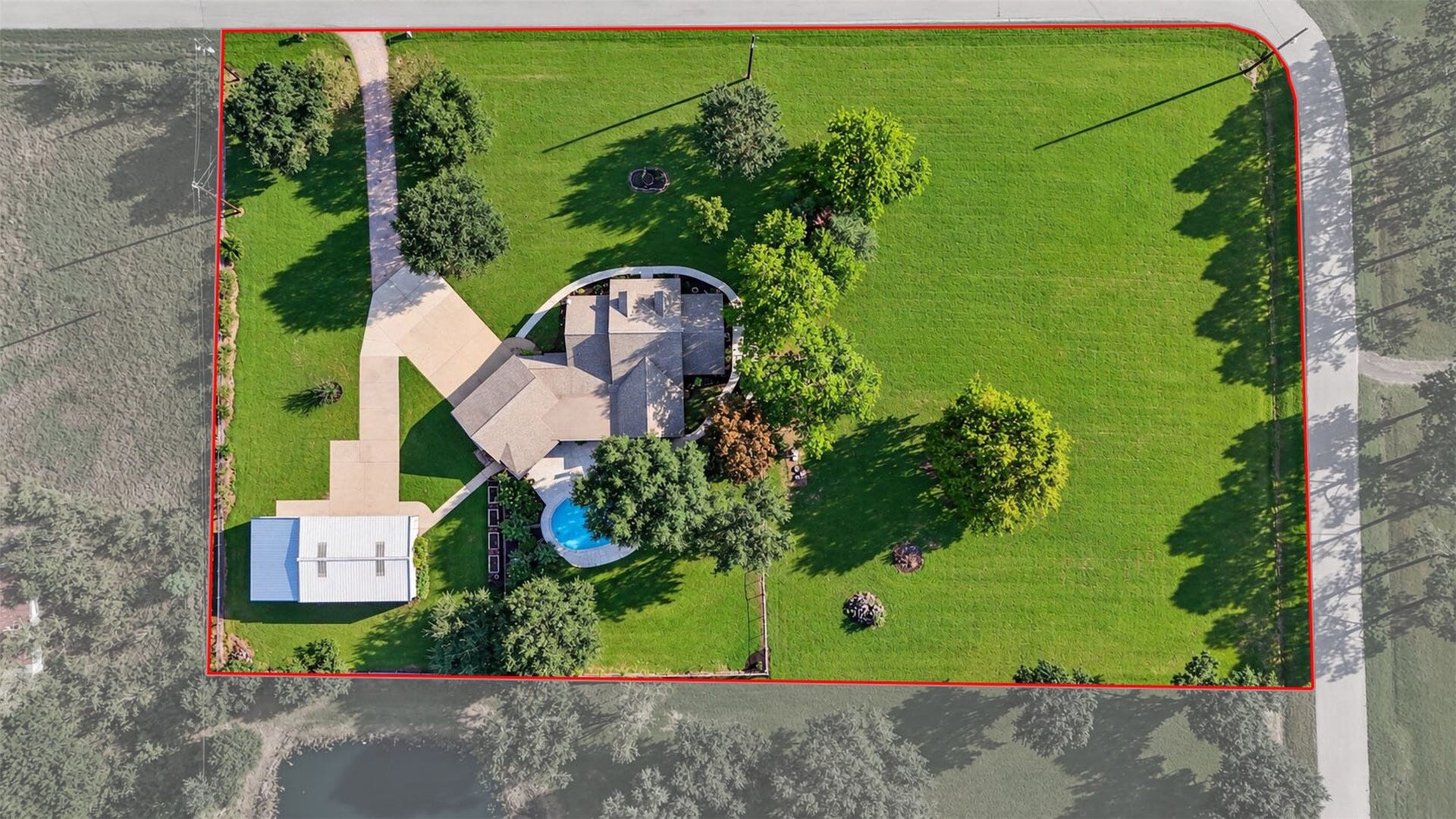 Overhead aerial highlights the home, pool, detached building, and expansive lawn. Boundary lines shown are approximate.