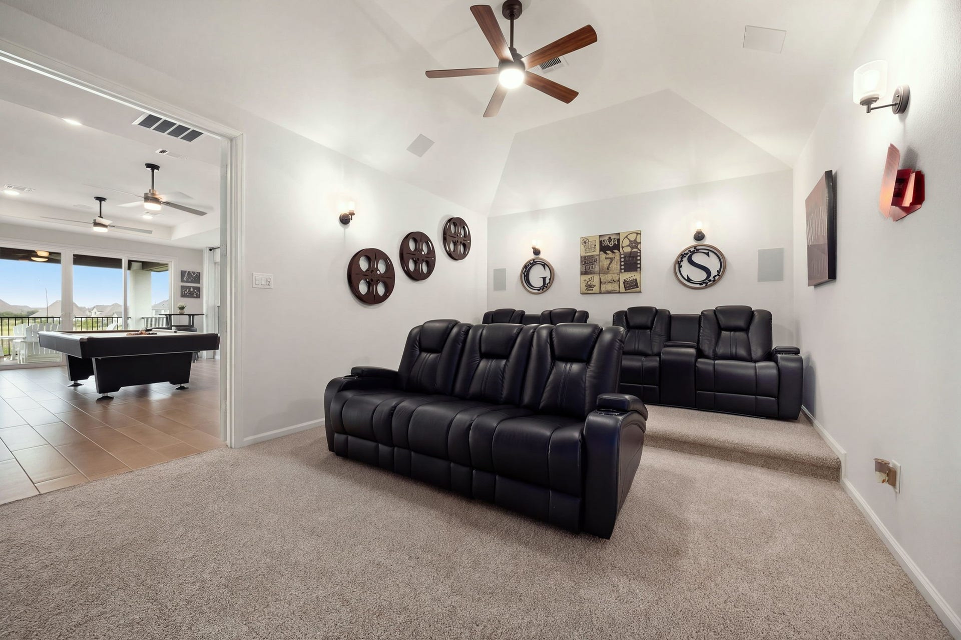 3026 Emerald Field Lane, Fulshear, TX 77423 A dedicated home theater delivers a cinematic experience with full surround sound speakers, a subwoofer, ambient uplighting, and a ceiling fan, complemented by elevated tiered flooring designed for an immersive movie-watching experience