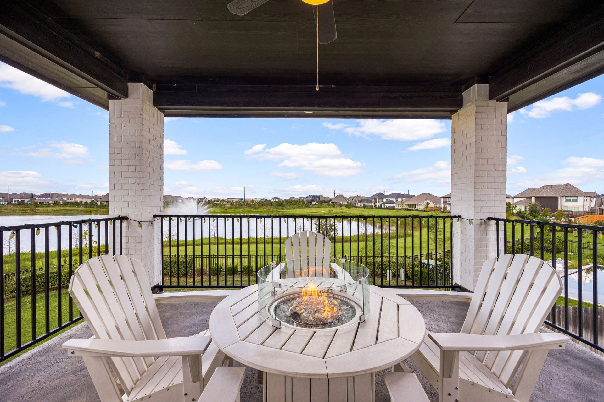 3026 Emerald Field Lane, Fulshear, TX 77423 Elevate your outdoor living experience with a private second-floor retreat overlooking serene lake views, complete with inviting lounge seating and a central fire pitthe perfect setting to unwind in luxury.