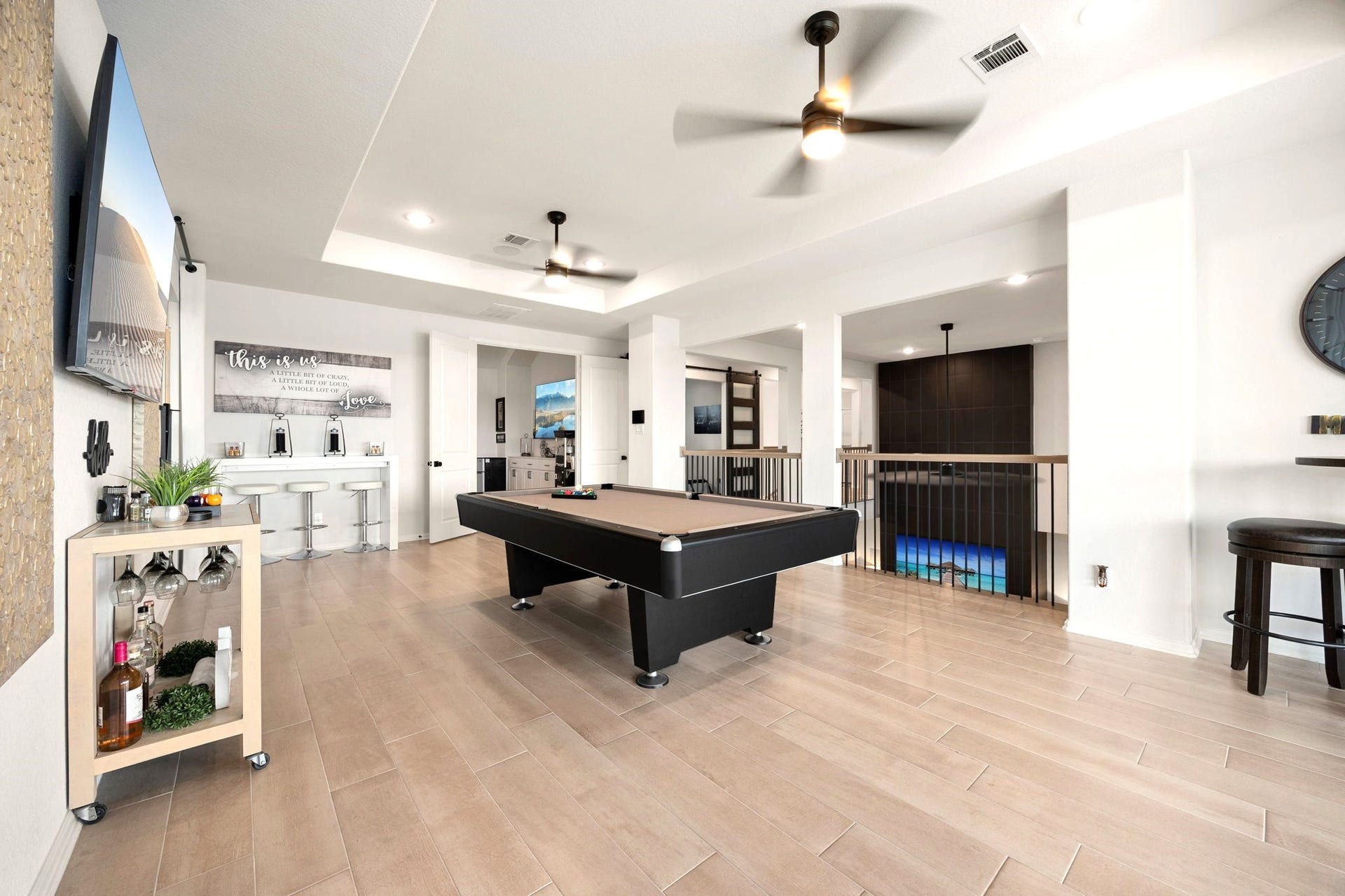 3026 Emerald Field Lane, Fulshear, TX 77423 The spacious upstairs game room offers a seamless transition to a dedicated theater room through elegant double doors, creating the ultimate entertainment experience for movie nights, game days, and gatherings with family and friends.