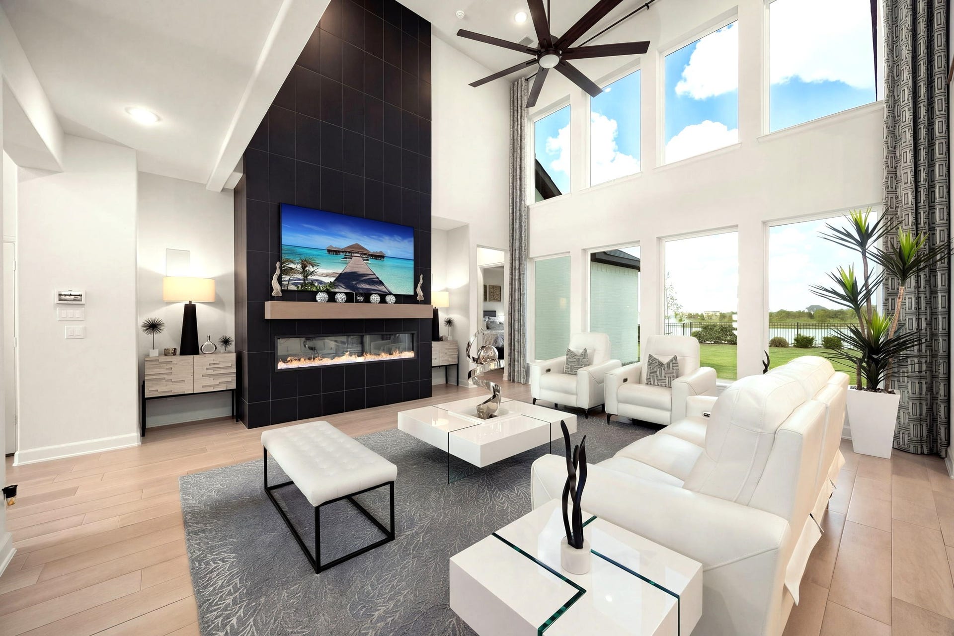 3026 Emerald Field Lane, Fulshear, TX 77423 A stunning electric fireplace framed by floor-to-ceiling stone tile creates a dramatic architectural focal point that elevates the living space with modern luxury and timeless sophistication.