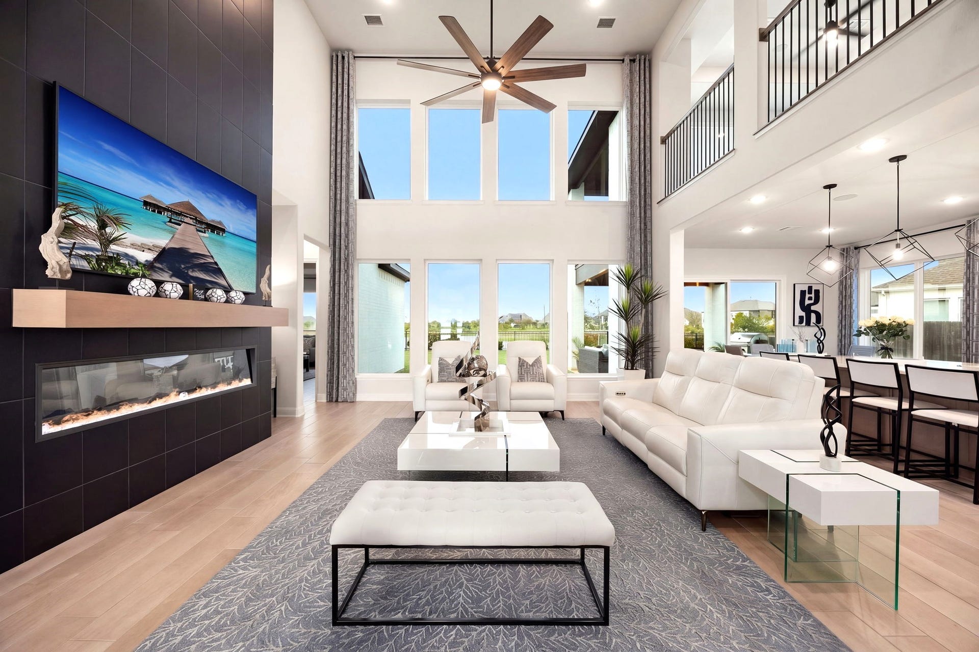 3026 Emerald Field Lane, Fulshear, TX 77423 Soaring two-story ceilings and eight expansive windows create a breathtaking living space filled with natural light and beautiful lake views. Window tinting helps manage afternoon sun while allowing you to enjoy the stunning scenery.