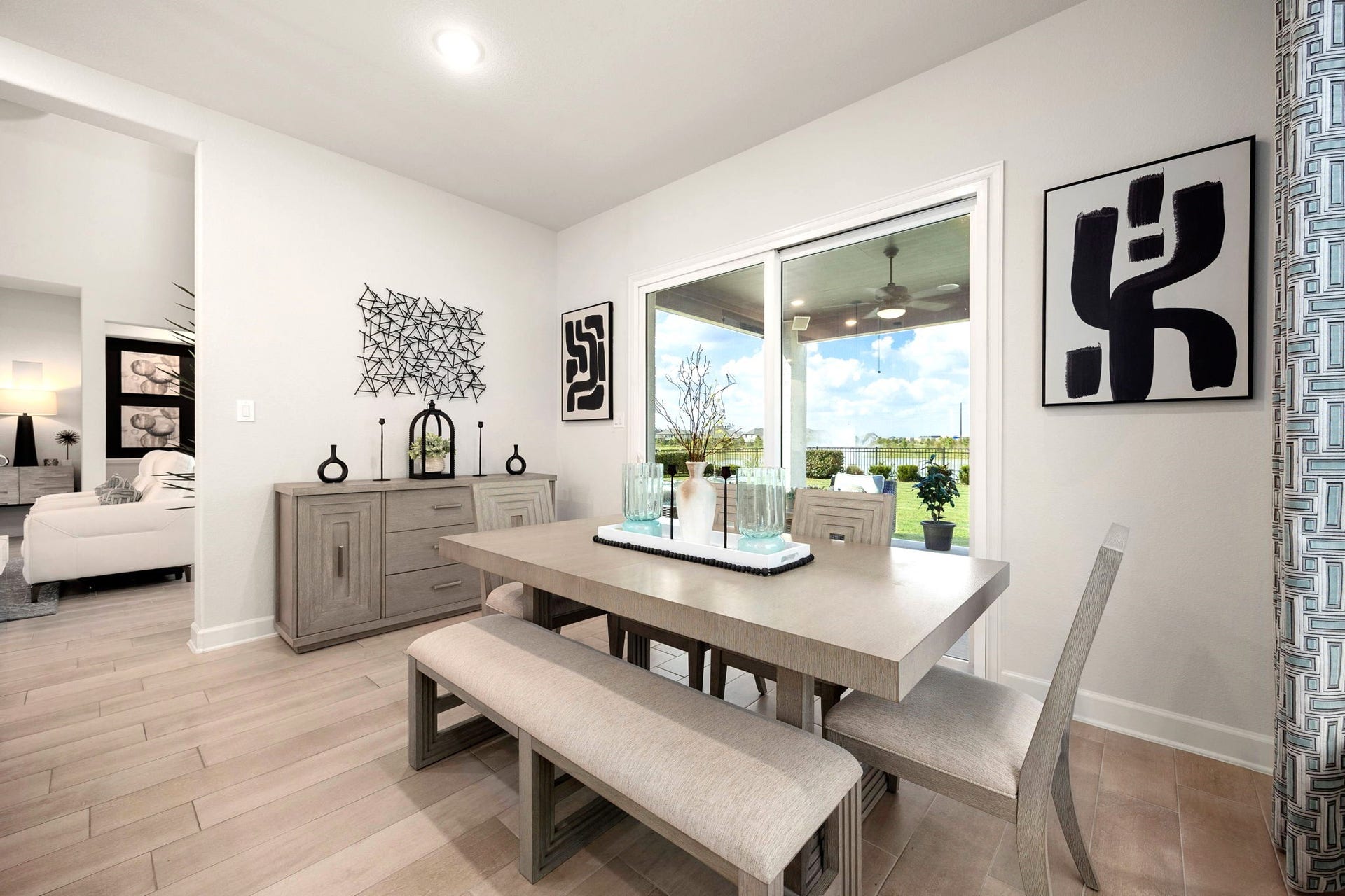3026 Emerald Field Lane, Fulshear, TX 77423 A spacious dining area features expansive sliding glass doors opening to a covered patio with an outdoor kitchen, creating an inviting indoor-outdoor setting perfect for elegant dinners, casual gatherings, and effortless entertaining.