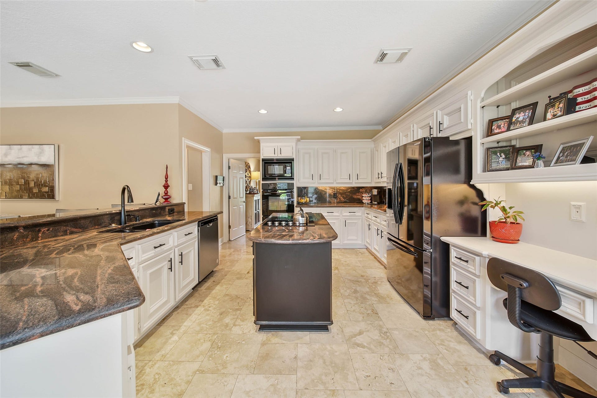 large workspace + storage + island + breakfast bar + built-in desk + sightlines into living areas.