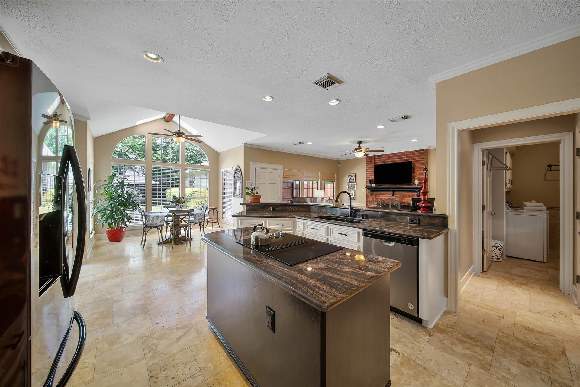 Spacious kitchen with abundant cabinetry, island workspace, breakfast bar and open views toward the home's everyday gathering spaces.