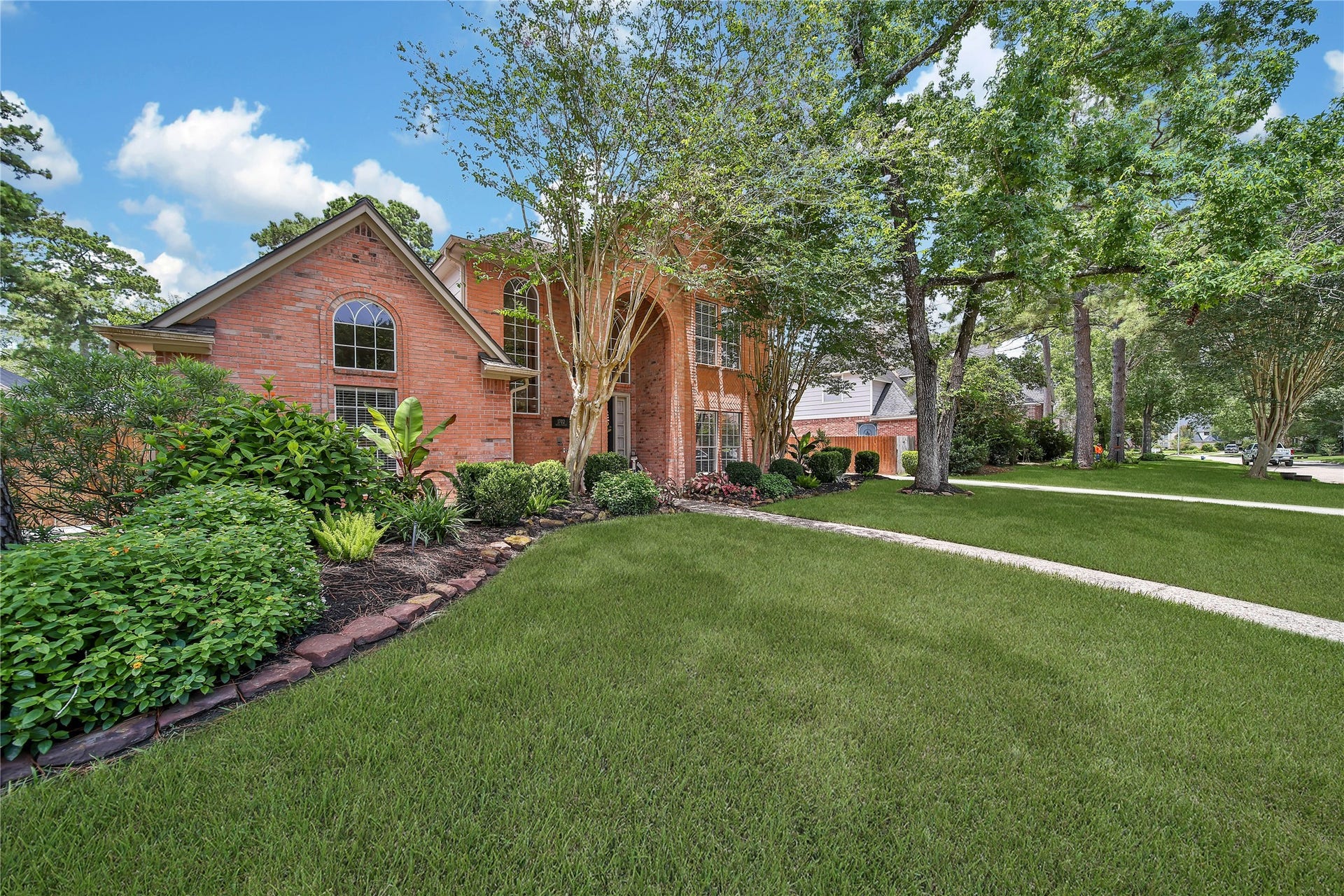Traditional Kings Point architecture framed by mature trees at 1702 Seven Maples in Kingwood's 77345 ZIP code.