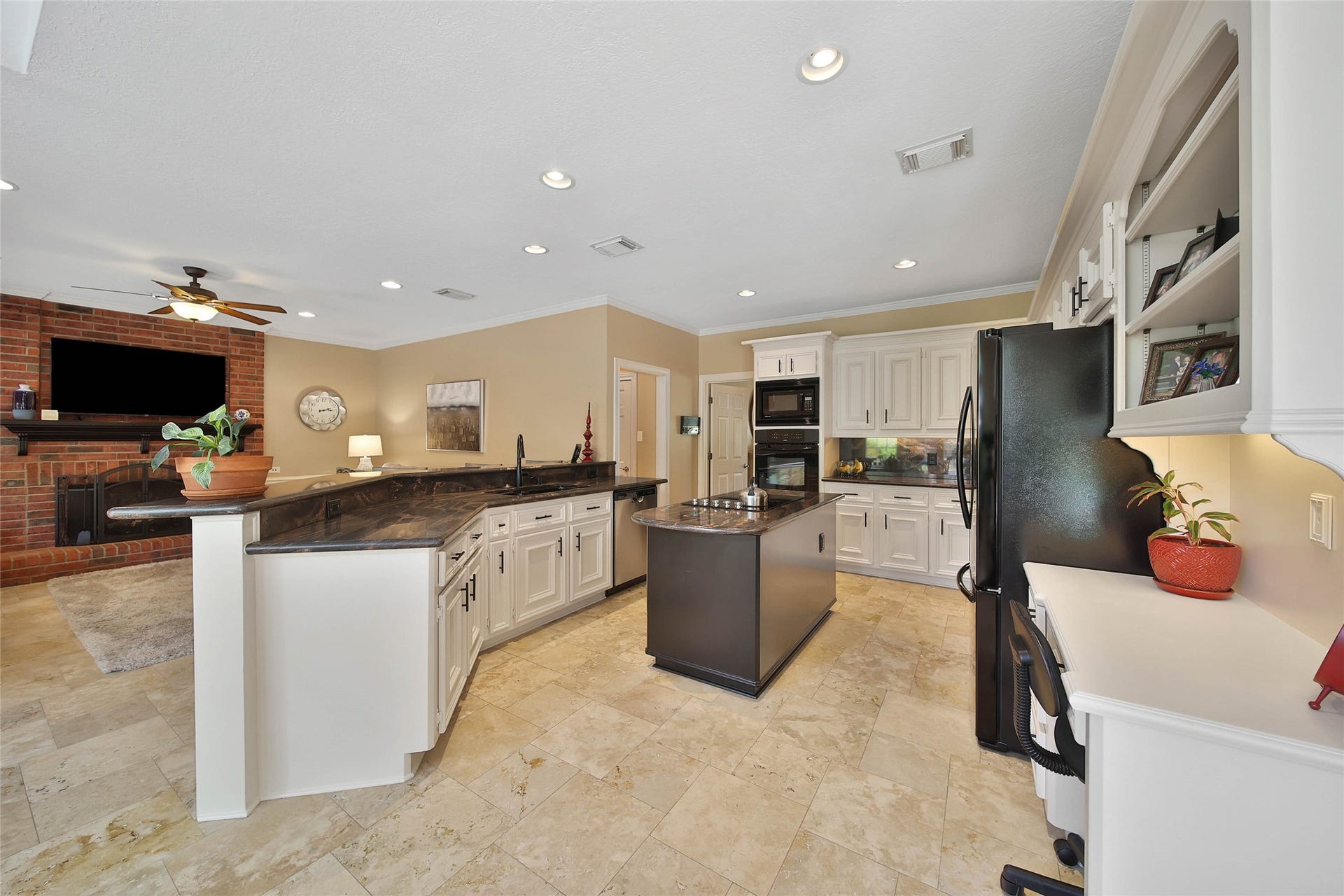 Spacious Kingwood kitchen with extensive cabinetry, island workspace, breakfast bar and built-in desk.