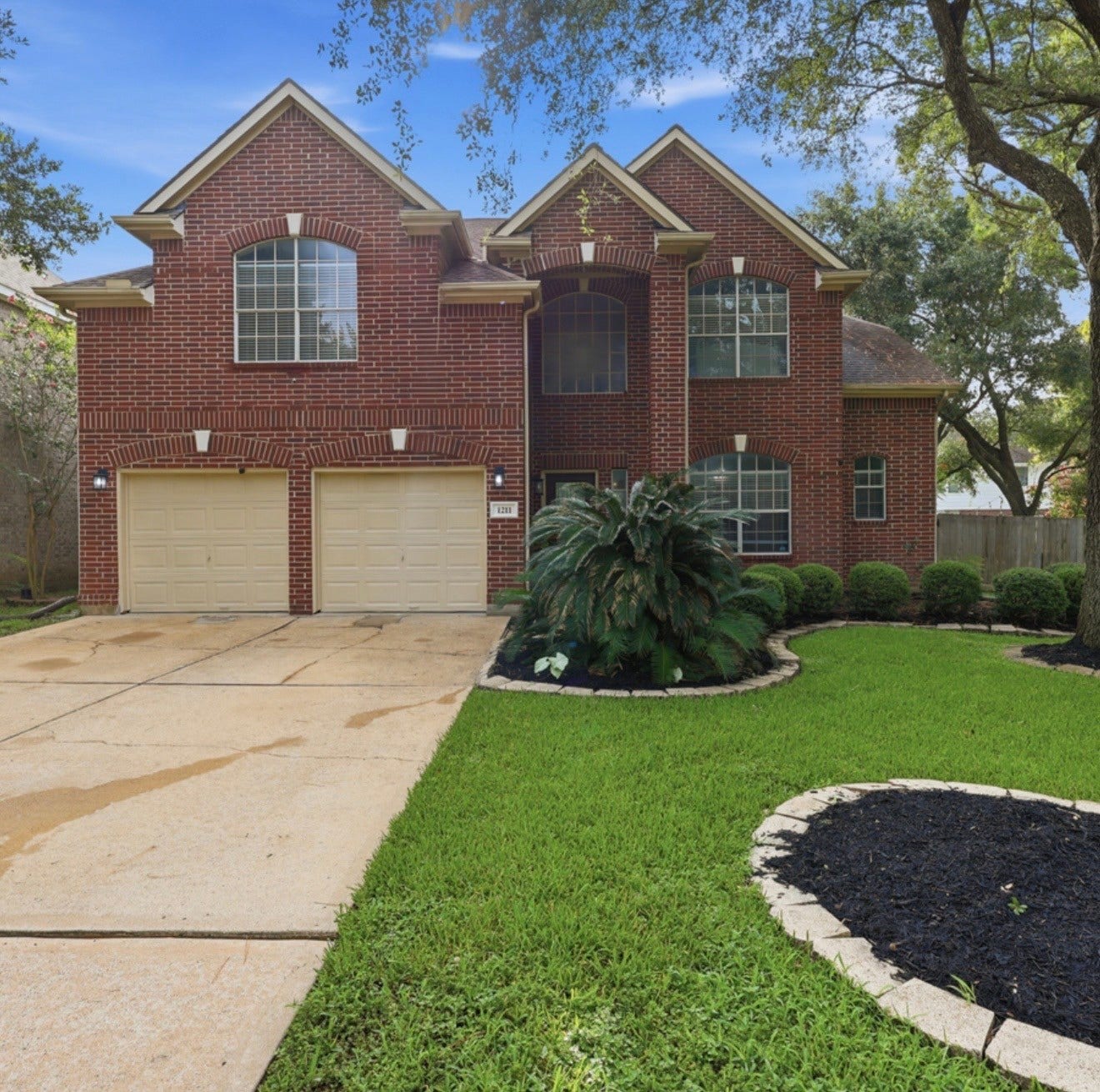 1211 Ragsdale Lane, Katy, TX 77494 Charming two-story brick home with elegant arched windows, a double garage, and beautifully landscaped front yard nestled in a serene neighborhood.