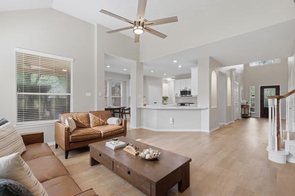 1211 Ragsdale Lane, Katy, TX 77494 Spacious open-concept living area with sleek hardwood floors, modern ceiling fan, and abundant natural light, seamlessly connecting to a bright kitchen with a breakfast bar.