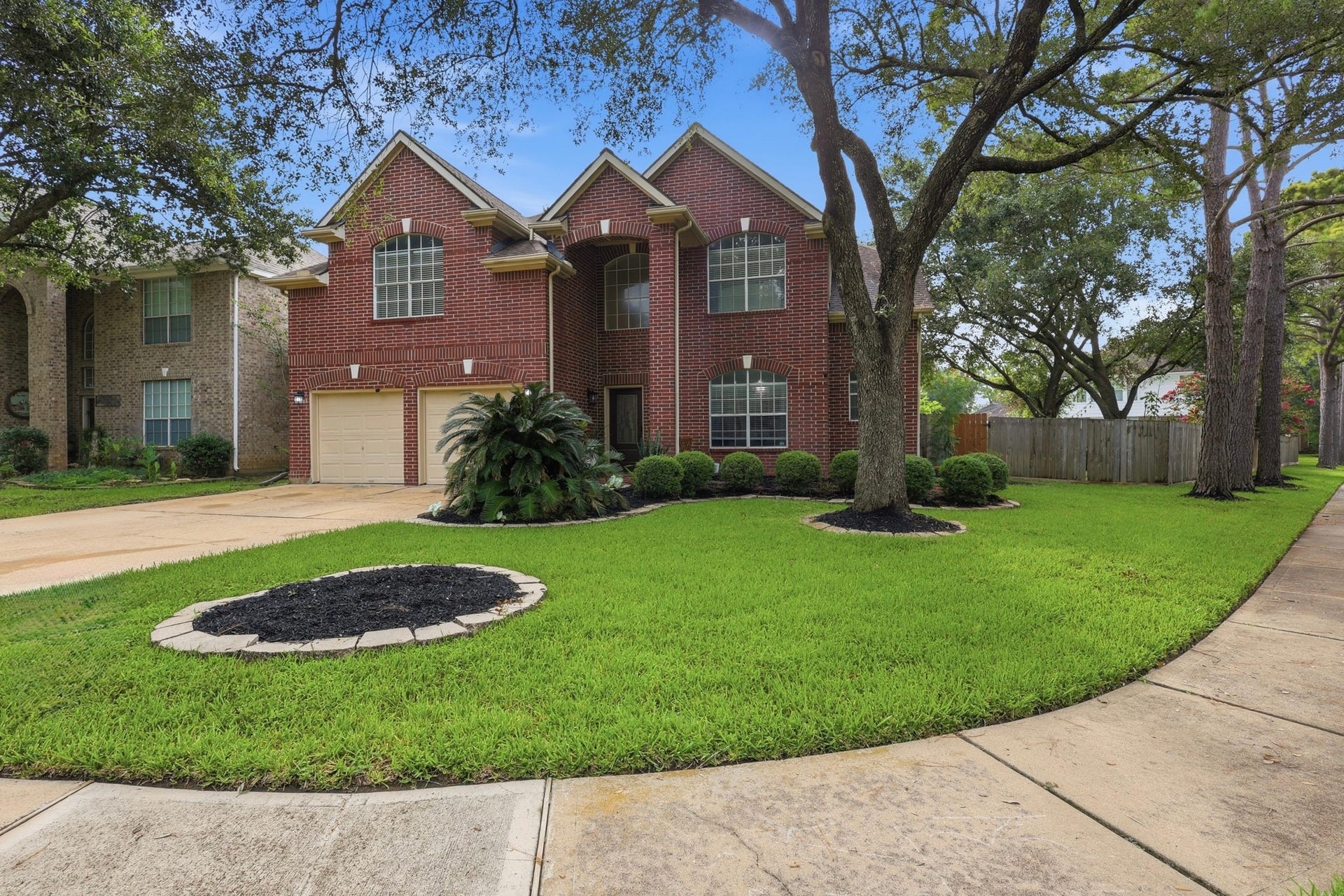 1211 Ragsdale Lane, Katy, TX 77494 Charming two-story brick home with a spacious two-car garage and beautifully landscaped front yard, nestled on a serene tree-lined street.