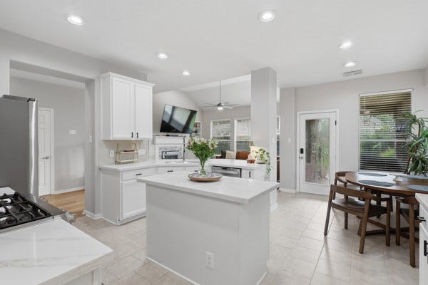 1211 Ragsdale Lane, Katy, TX 77494 Bright and modern kitchen with sleek white cabinetry, a central island, and stainless steel appliances. The open-concept layout flows into a cozy living area with abundant natural light, perfect for entertaining or family gatherings.