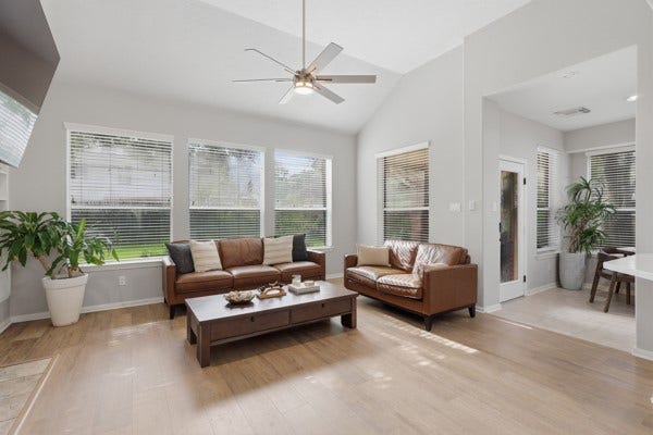 1211 Ragsdale Lane, Katy, TX 77494 Bright and inviting living space with high ceilings, large windows, and stylish wood flooring, perfect for relaxation and gatherings.