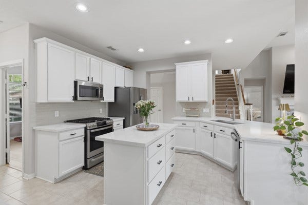 1211 Ragsdale Lane, Katy, TX 77494 Bright and spacious kitchen with modern stainless steel appliances, elegant white cabinetry, and a functional center island, perfect for culinary activities and entertaining.