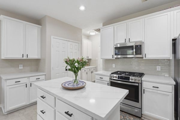 1211 Ragsdale Lane, Katy, TX 77494 Modern kitchen featuring sleek white cabinetry, stainless steel appliances, and a spacious island with elegant countertops.