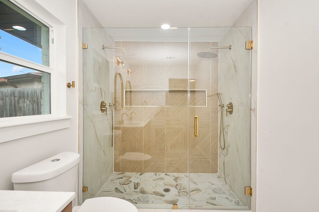 6106 Rutherglenn Drive, Houston, TX 77096 Spa-inspired bathroom showcasing oversized walk-in shower and elegant designer finishes.