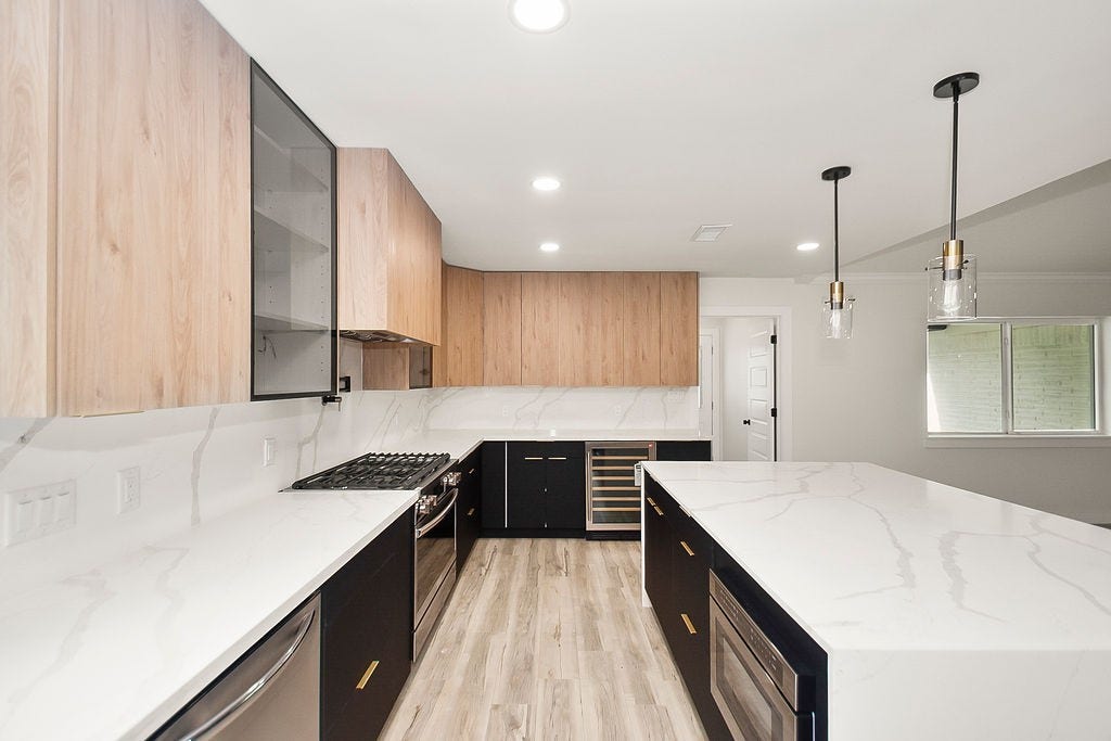 6106 Rutherglenn Drive, Houston, TX 77096 Bright galley-style kitchen with oversized waterfall island and abundant storage space.