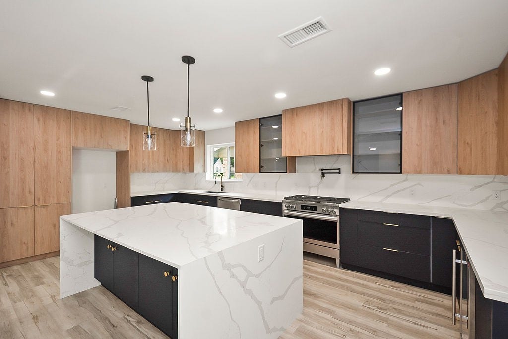 6106 Rutherglenn Drive, Houston, TX 77096 Designer kitchen featuring quartz countertops, custom European-style cabinetry, and modern lighting.