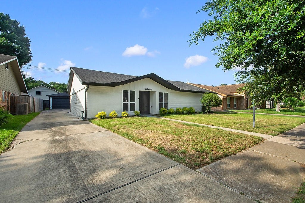 6106 Rutherglenn Drive, Houston, TX 77096 Front exterior view showcasing the spacious driveway, updated finishes, and expansive front yard.