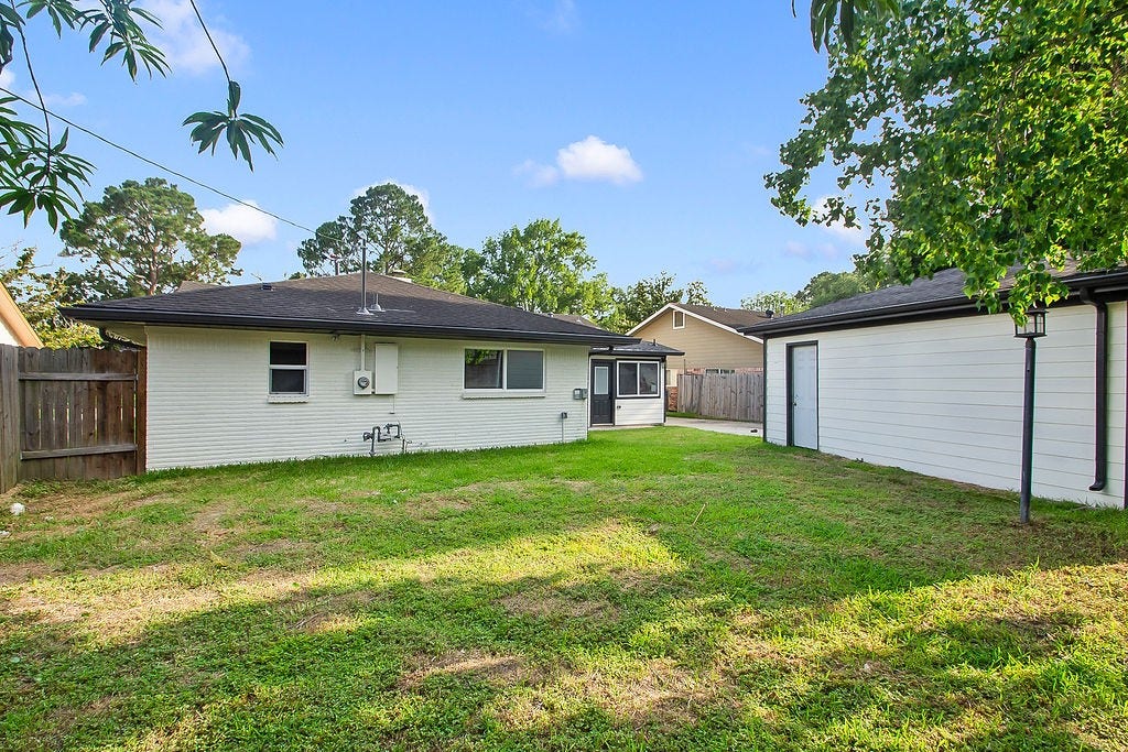 6106 Rutherglenn Drive, Houston, TX 77096 Expansive fully fenced backyard offering generous green space for recreation and entertaining.
