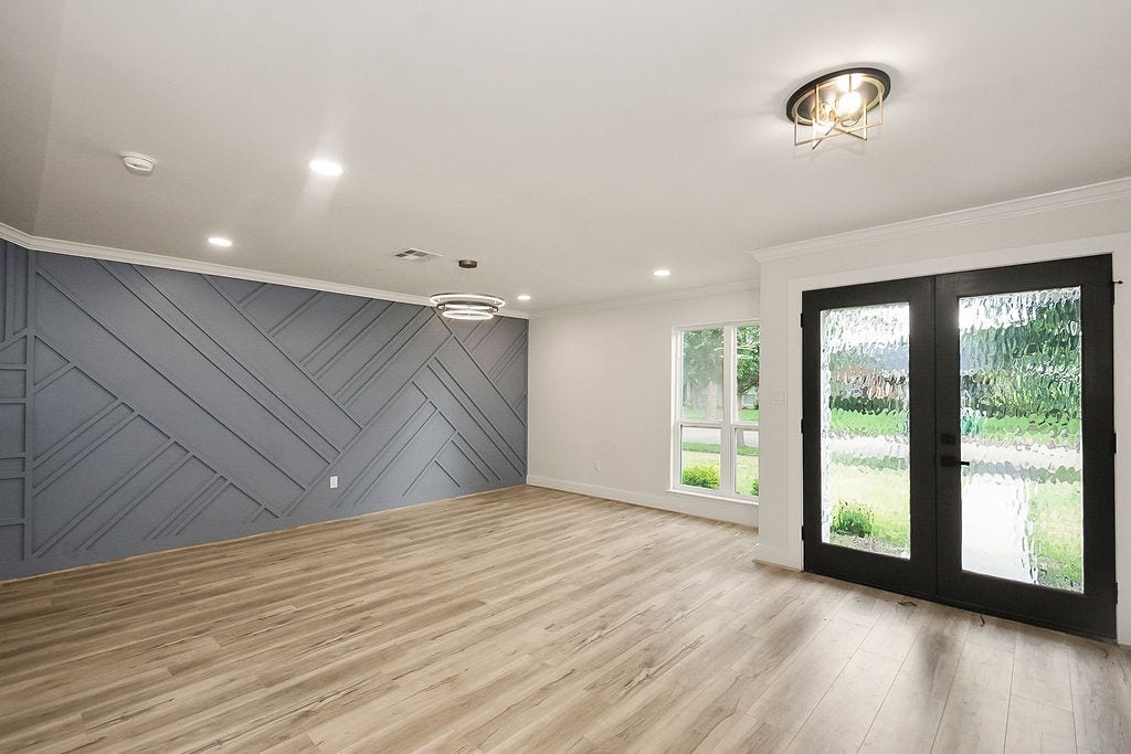 6106 Rutherglenn Drive, Houston, TX 77096 Expansive living area filled with natural light and views of the backyard through oversized glass doors.