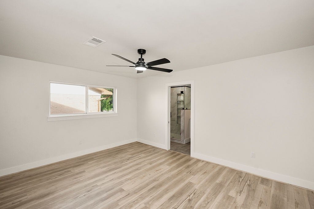 6106 Rutherglenn Drive, Houston, TX 77096 Bright secondary bedroom with updated flooring and modern ceiling fan.