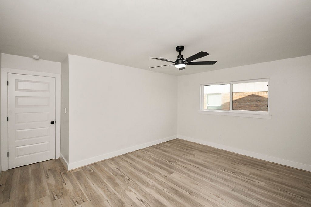 6106 Rutherglenn Drive, Houston, TX 77096 Bright and spacious additional bedroom with updated flooring and modern ceiling fan.