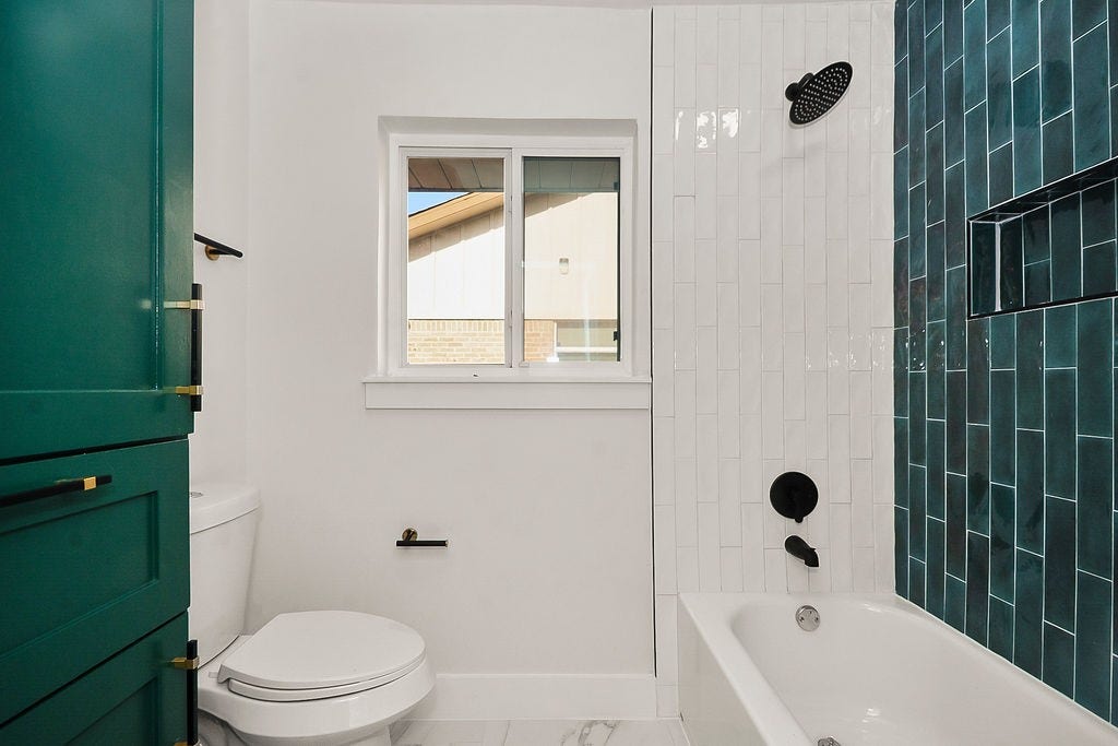 6106 Rutherglenn Drive, Houston, TX 77096 Updated bathroom featuring bold designer tile, modern fixtures, and contemporary finishes.