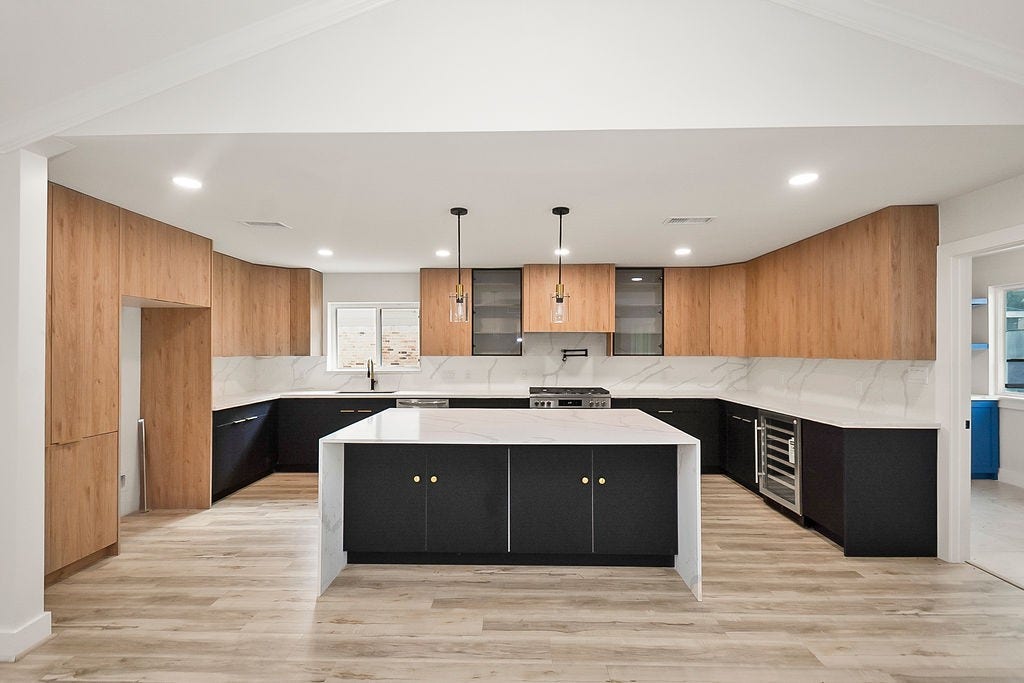 6106 Rutherglenn Drive, Houston, TX 77096 Beautifully redesigned kitchen featuring a massive waterfall island, quartz countertops, and sleek cabinetry.