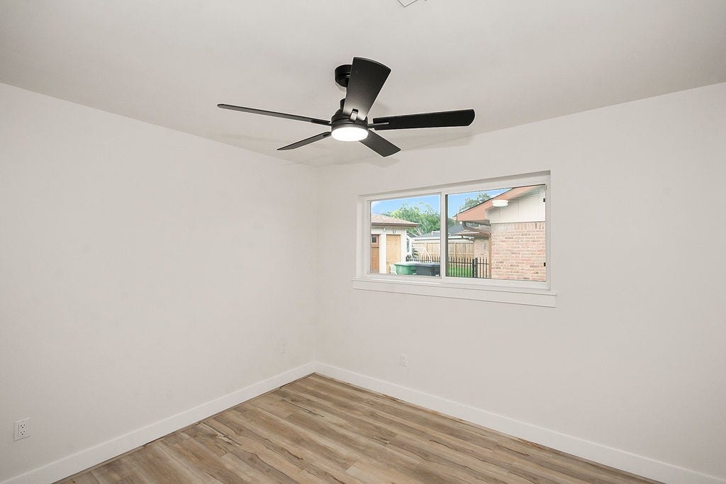 6106 Rutherglenn Drive, Houston, TX 77096 Another view of the additional bedroom with updated flooring and modern ceiling fan.