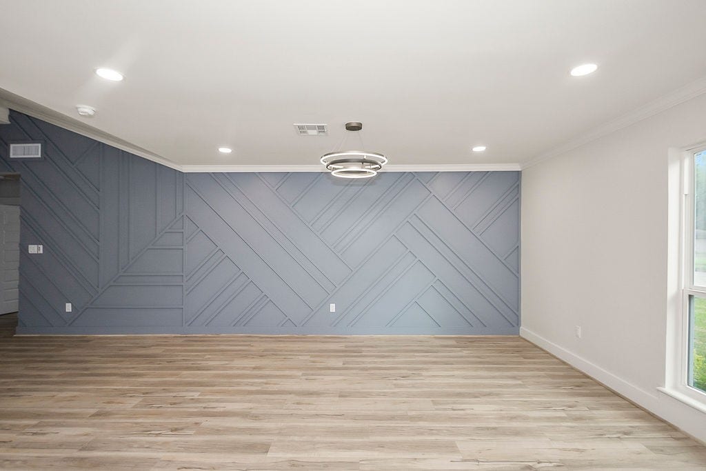 6106 Rutherglenn Drive, Houston, TX 77096 Another angle of the spacious living room showcasing designer accent walls and updated flooring.
