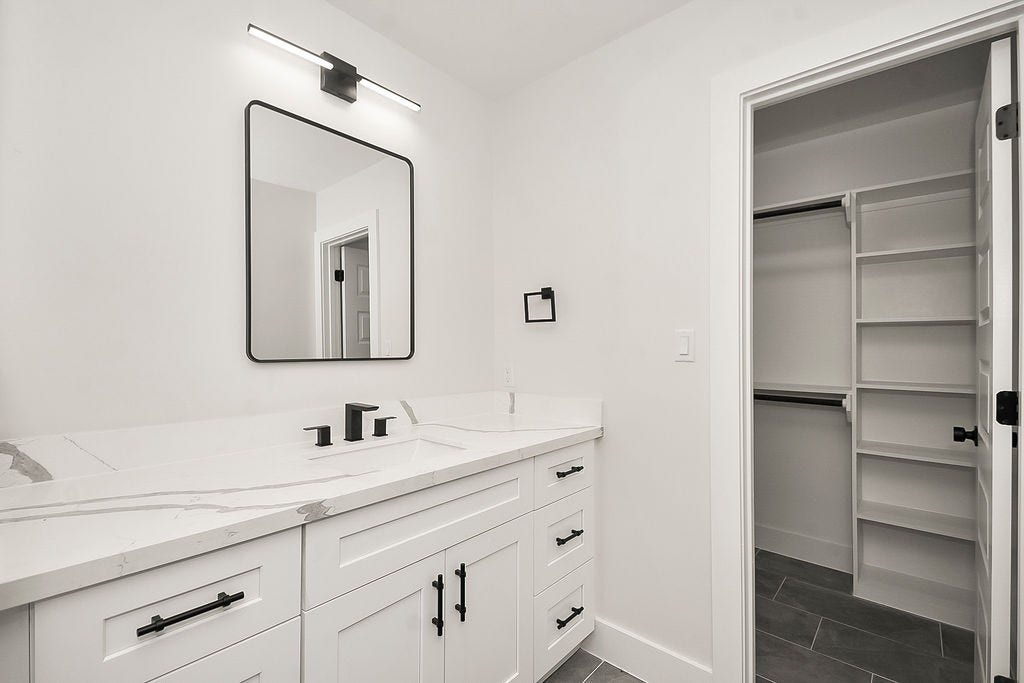 6106 Rutherglenn Drive, Houston, TX 77096 Modern vanity area with updated fixtures and direct access to spacious storage.