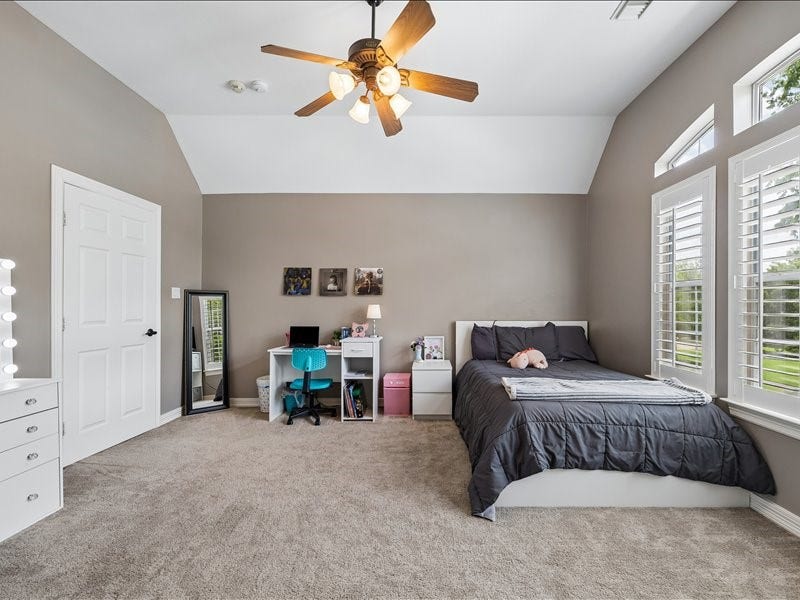 9007 Avebury Stone Circle, Missouri City, TX 77459 A bright and spacious secondary bedroom with vaulted ceiling, ceiling fan, plantation shutters, plush carpet, and generous square footage. Perfectly suited as a child's room, teen suite, or comfortable guest retreat.