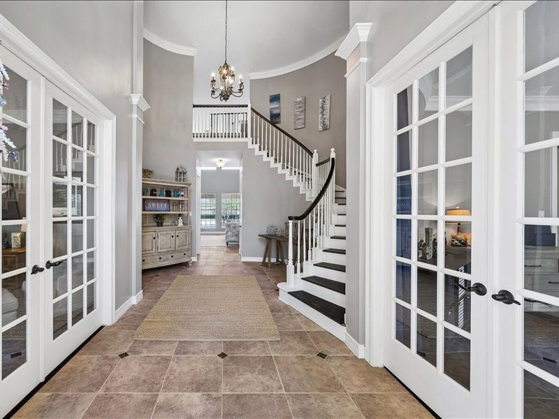 9007 Avebury Stone Circle, Missouri City, TX 77459 Make a lasting first impression in this soaring two-story foyer featuring tile floors with diamond insets, a graceful, curved staircase, an elegant chandelier, and French doors on each side leading to the study and the formal dining room (currently used as an extra bedroom).