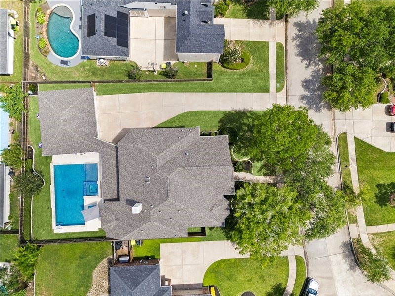 9007 Avebury Stone Circle, Missouri City, TX 77459 This stunning two-story home showcases a sparkling backyard pool, beautifully landscaped grounds, and an expansive driveway.